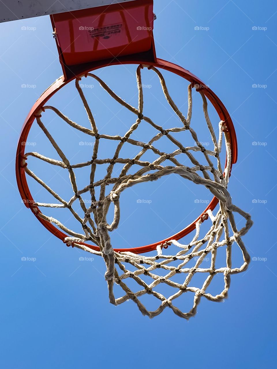 Basketball net on a beautiful sunny afternoon waiting for those slam dunks during game play 