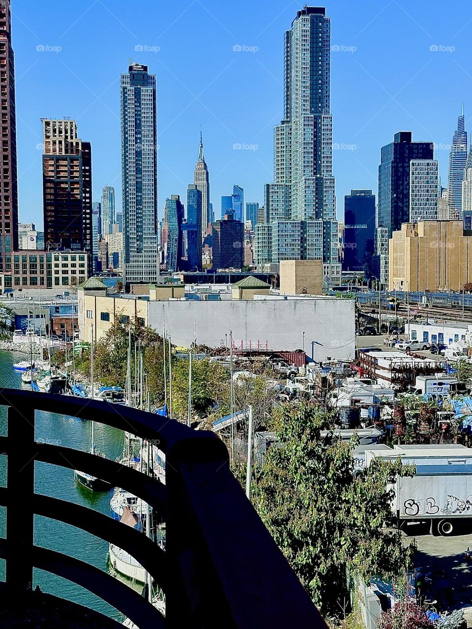 This is a view from the pedestrian lane of the „Pulaski Bridge“ at „Newtown Creek“ in LIC, Queens featuring LIC as well as „Manhattan“ in the distance on a warm sunny Indian summer afternoon in early November 2023. Hypnotic Productions