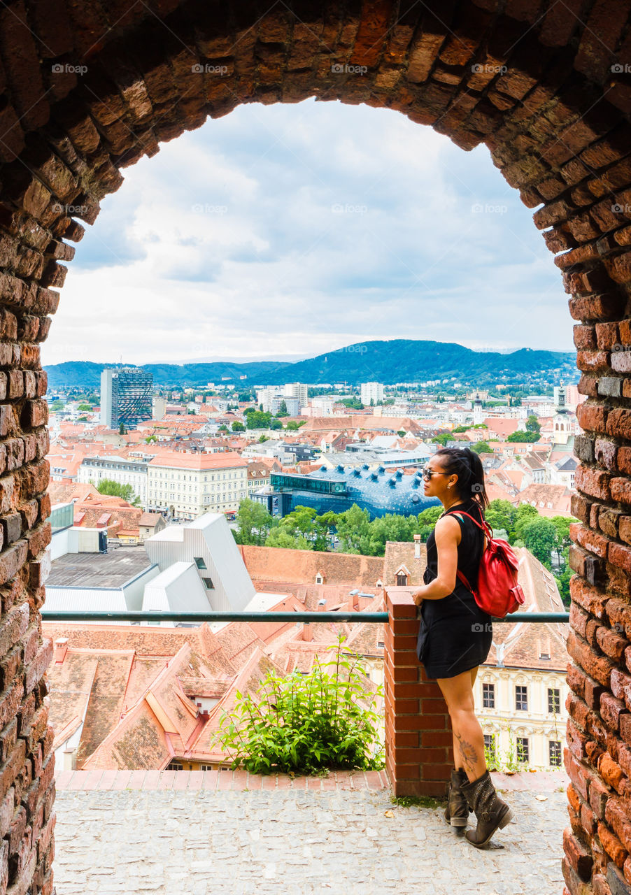 Look over the city. Asian woman looking over view of Graz city on hill, Austria.