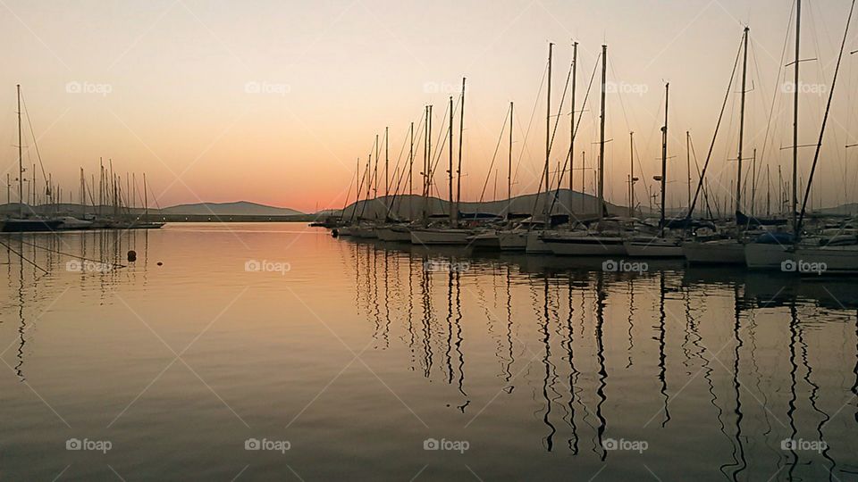 boat reflection by sunset in sardinia