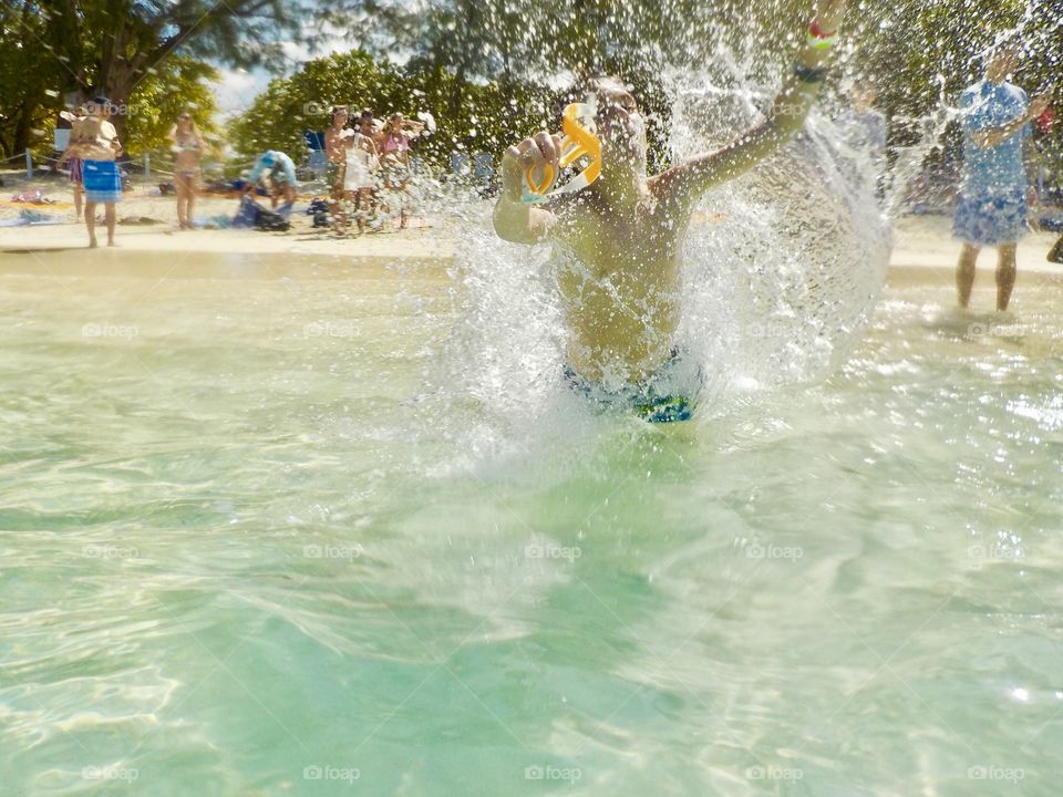 Let the vacation begin mission, boy running into sea, Grand Cayman Islands .  