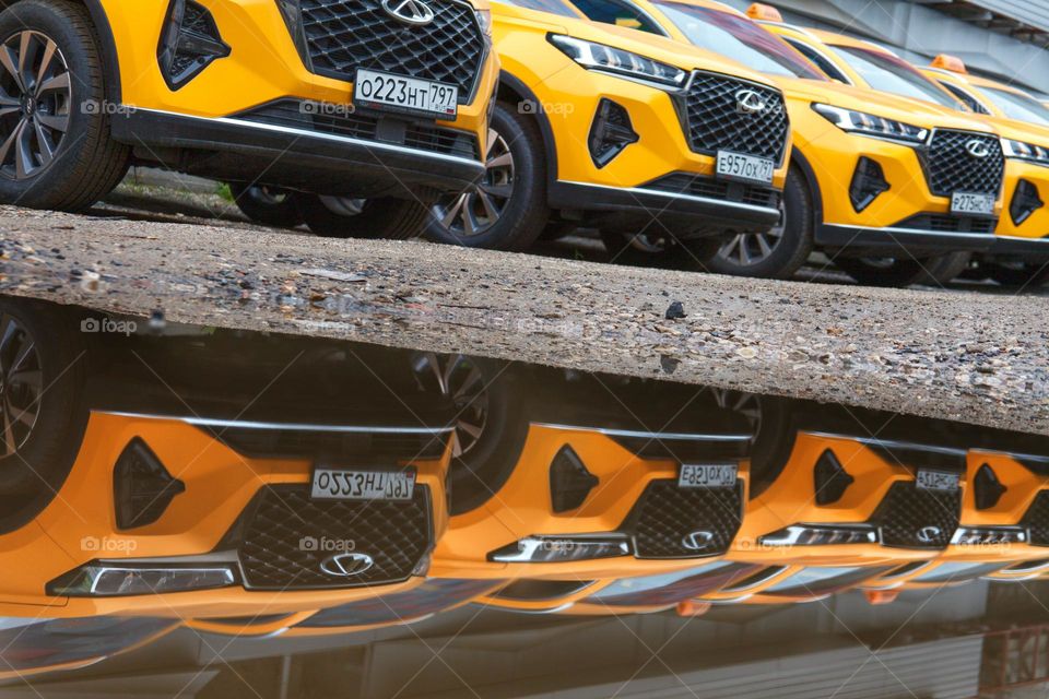 close photo of a taxi in the reflection of water