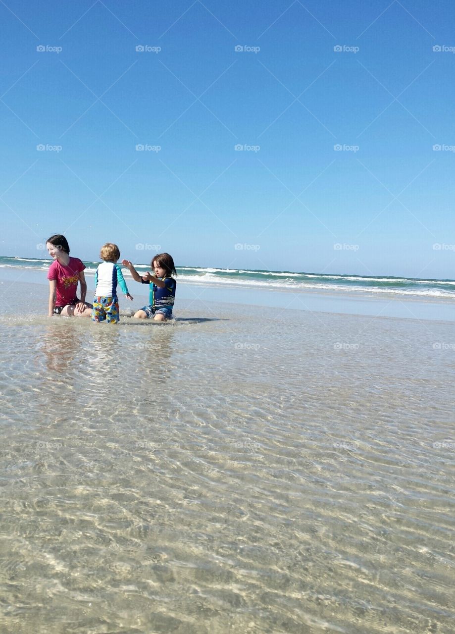 Children Playing on Florida Beach Vacation in Sand and Surf