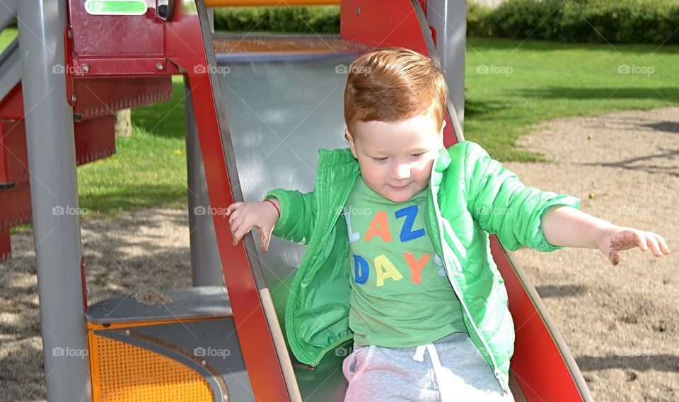 Cute boy on slide at playground
