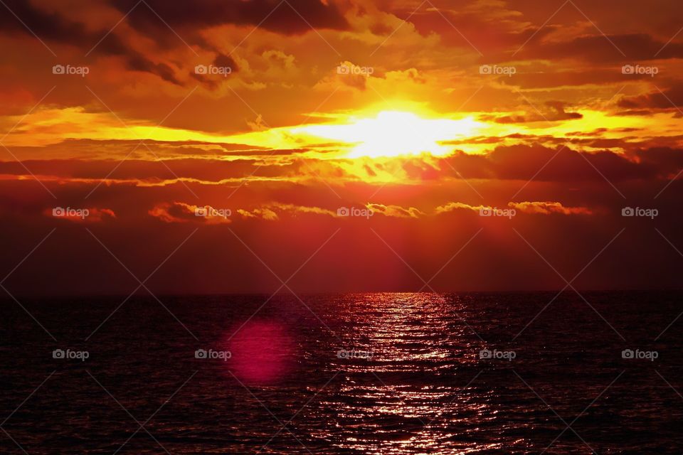 Spectacular blazing-red and golden sunset over the ocean. 