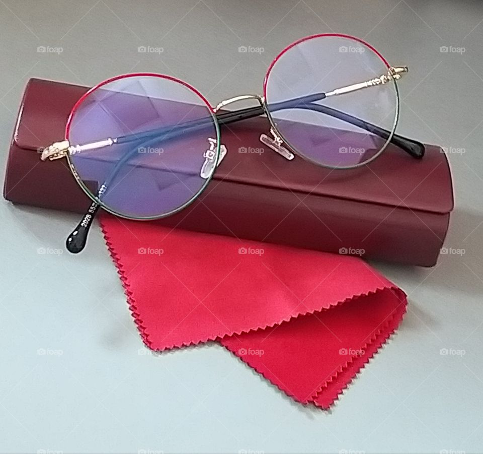 red rag napkin round metal optical glasses and case on table