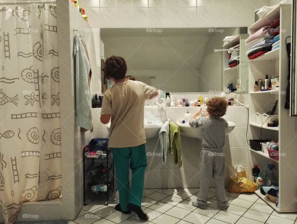 two kids brushing teeth at two sinks