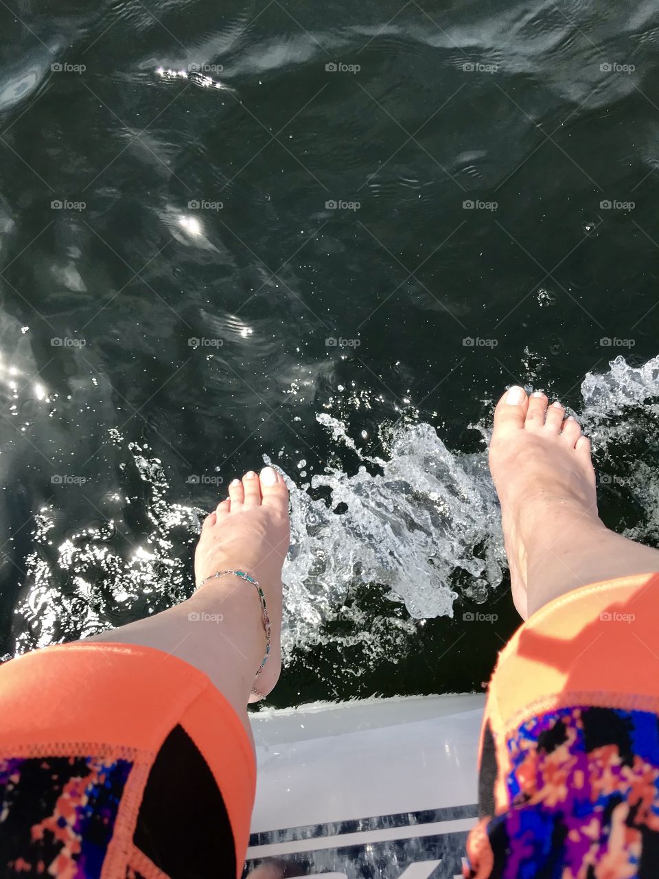 Hanging 10 over the side of the sailboat to feel the cool water spray