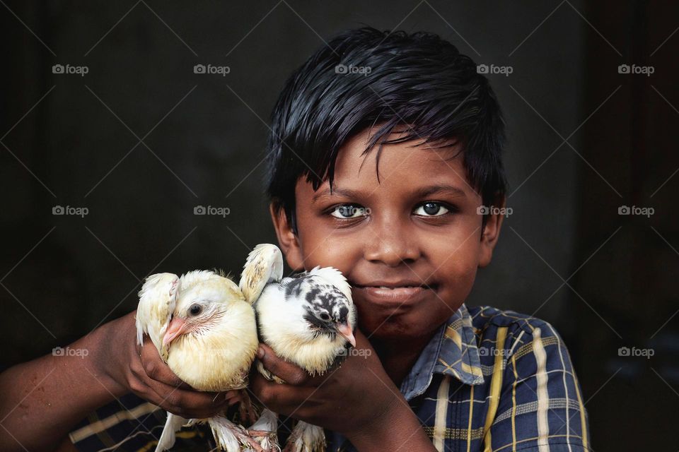 Little boy holding two pigeons