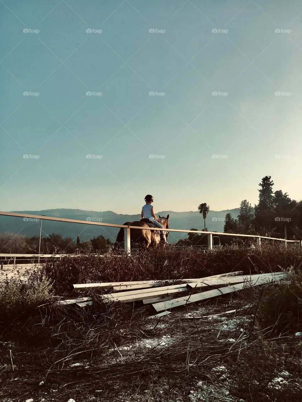 A boy rides into the sunset