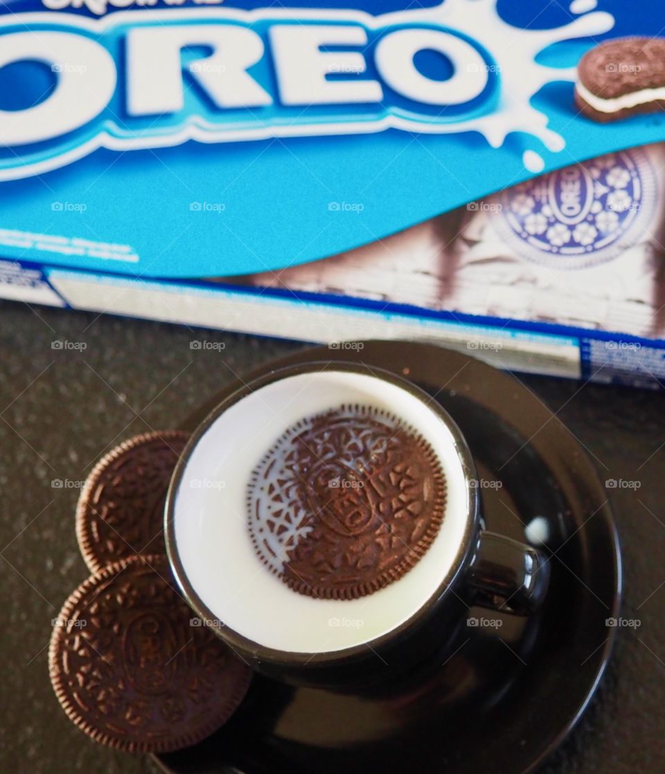 Oreo cookies with cup of milk and package.