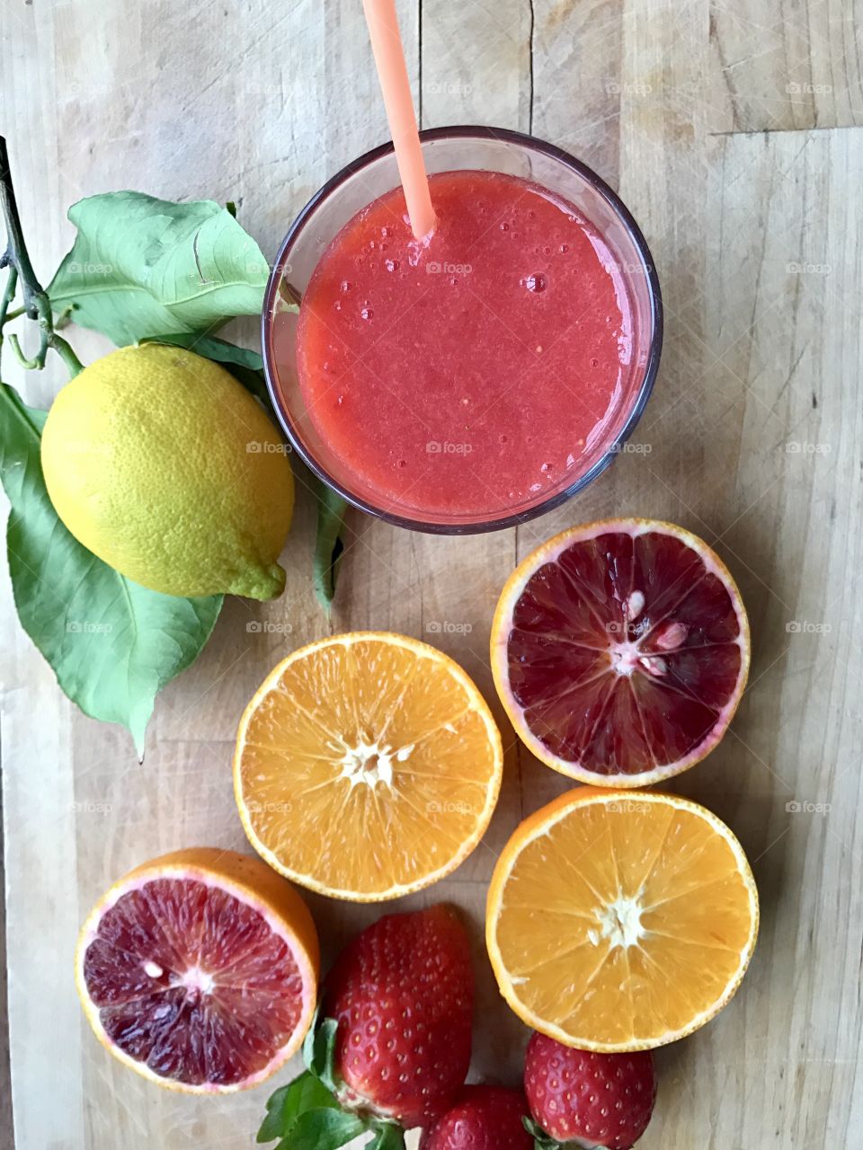 Grapefruit juice and ripe grapefruits on a wooden table