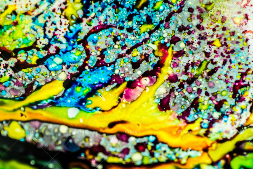 The ink to refill the printer cartridge was spilled onto the white washbasin and the paints blended into abstract drips and patterns.