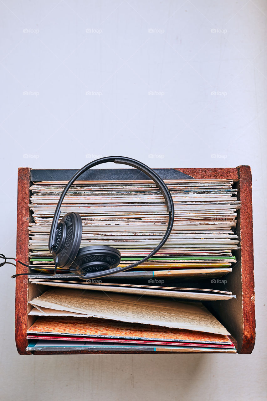 Stack of black vinyl records, turntable vinyl player and headphones. Classic stereo set. Candid people, real moments, authentic situations