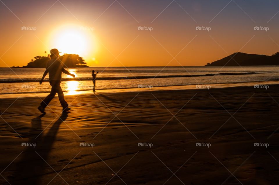Two people on the beach at sunrise