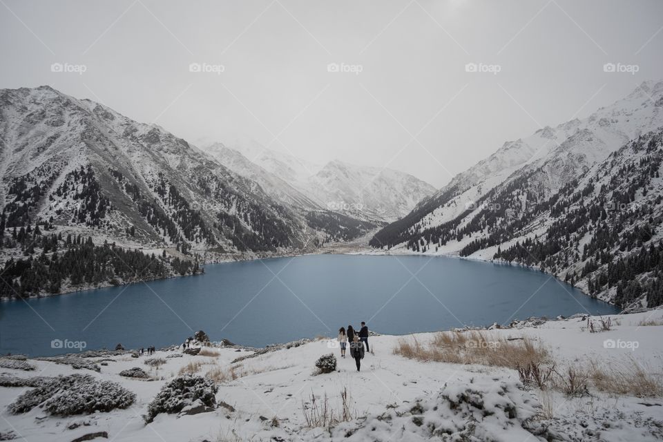 Snow mountain and pine forest at beautiful blue big Almaty lake in Kazakhstan