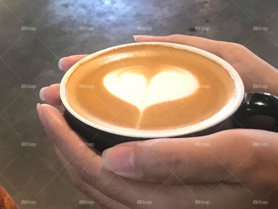 Hands is holding a cup of cappuccino, enjoy in the morning 