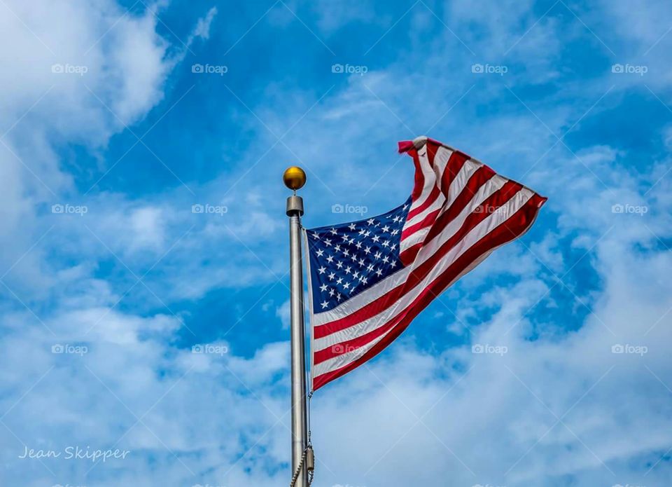 American flag against cloudy sky