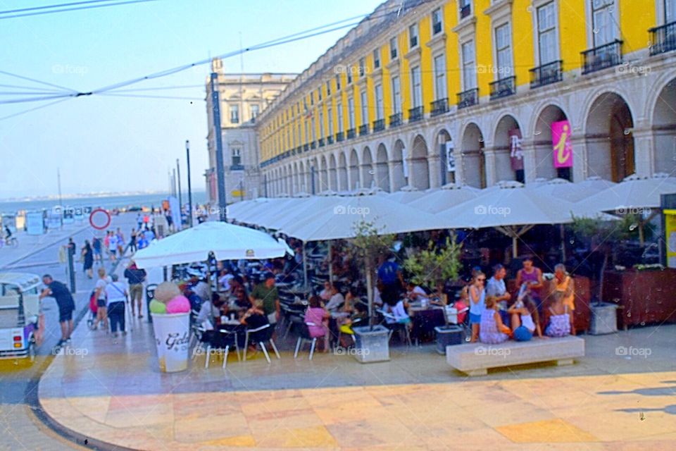 People enjoying the atmosphere and the food in the the square of praca do comercia in Lisbon 