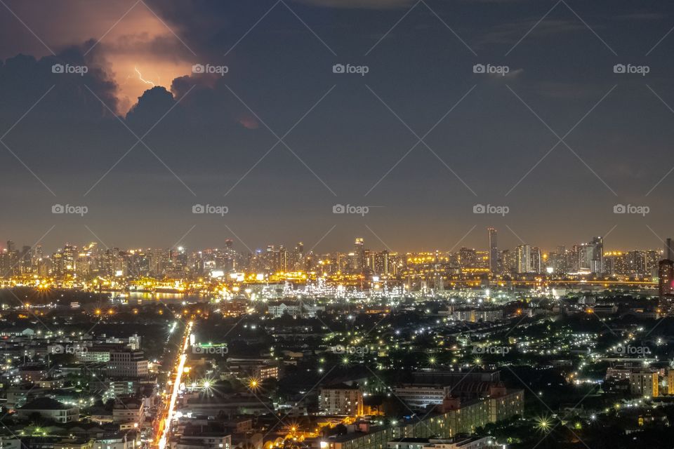 Night scape of skyscraper in the rain season of Bangkok