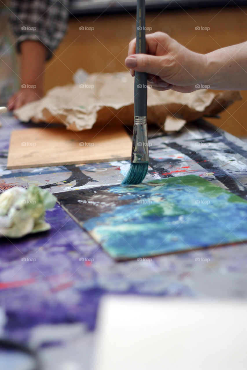 An artist paints with encaustic on canvas