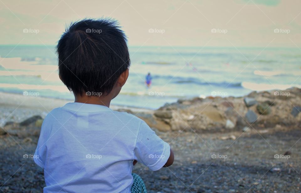 A child staring at the sea