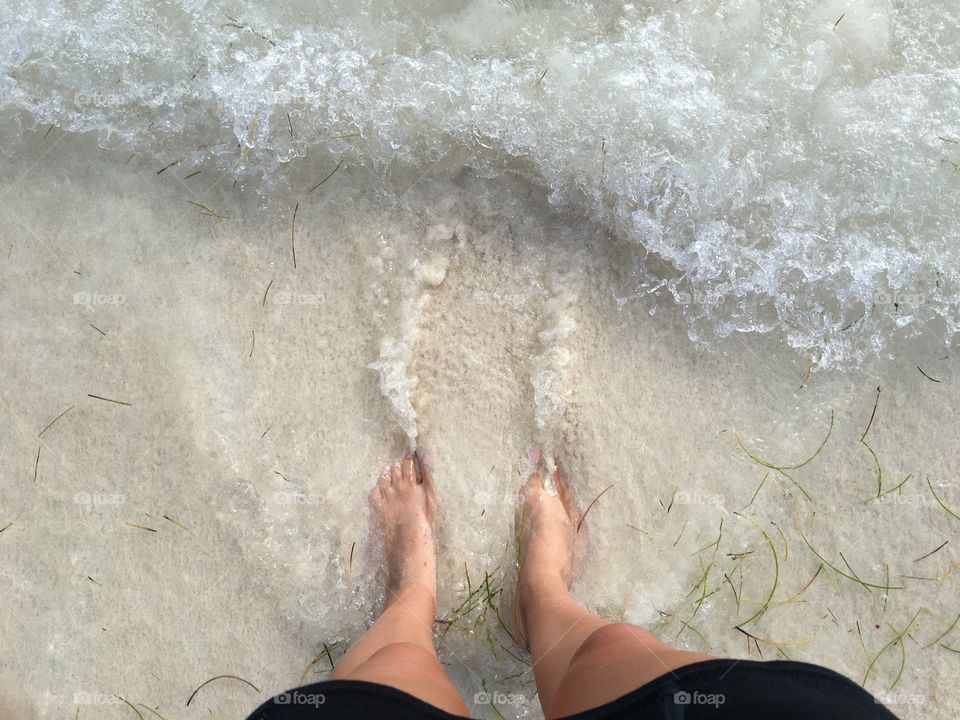 Wading barefoot on the beach.