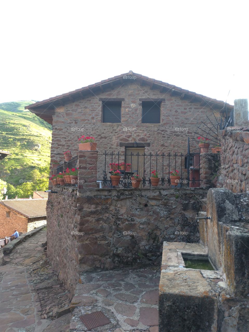 Fuente y casa de piedra en un pueblo