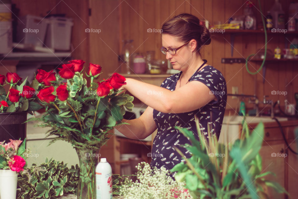 Woman Arranging Roses in a Vase at a Flower Shop