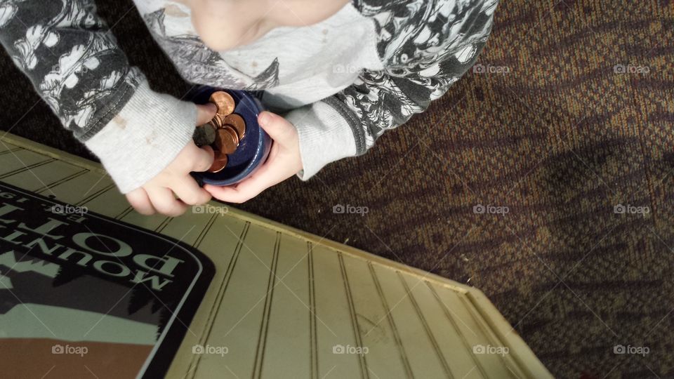 child's hands in penny cup