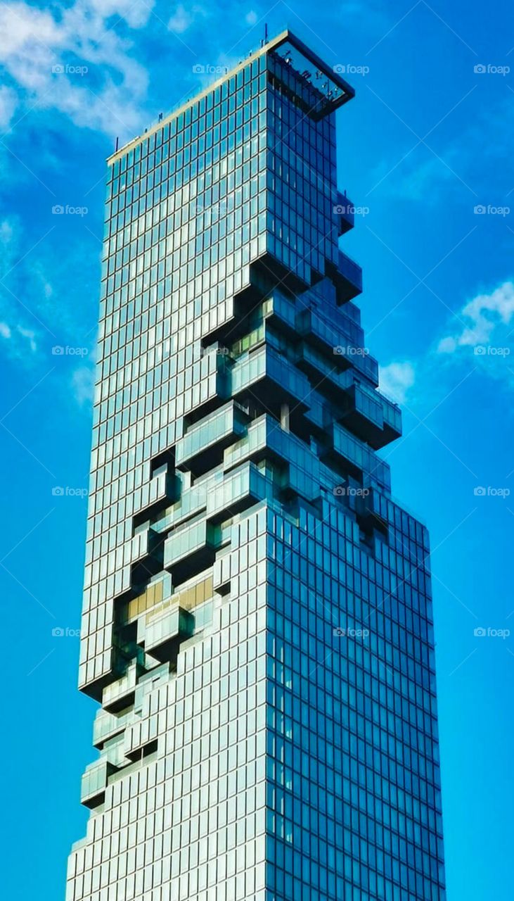 A view of Mahanakhon Tower from Sathorn Road. Taken in Bangkok, Thailand. It's blue on blue.
