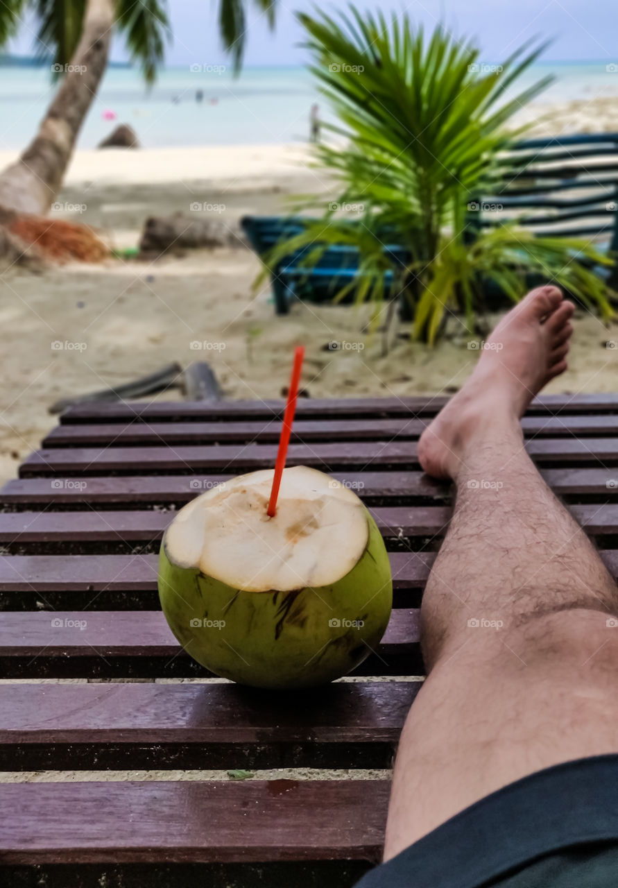 Relaxing holidays on a beach with a sip of coconut