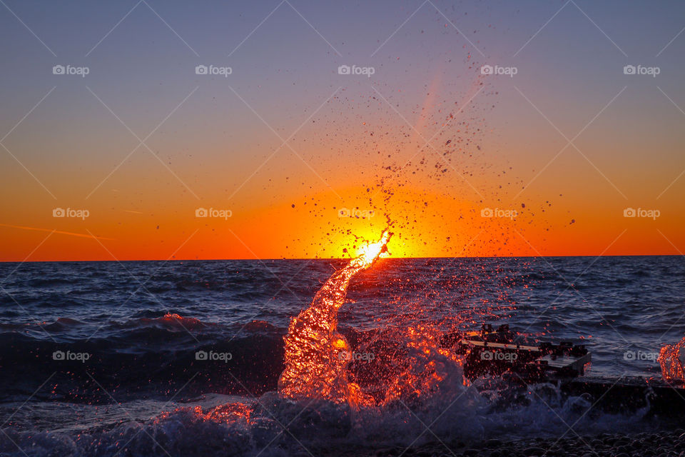 Amazing shot of a sunset as the waves crash.