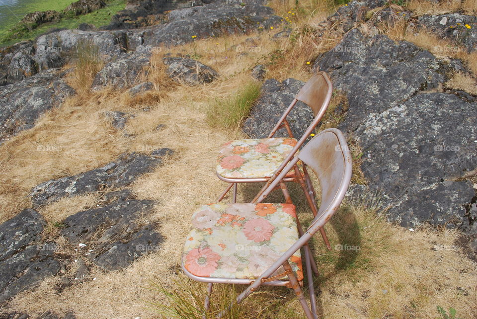 Rusty chairs on the rocks