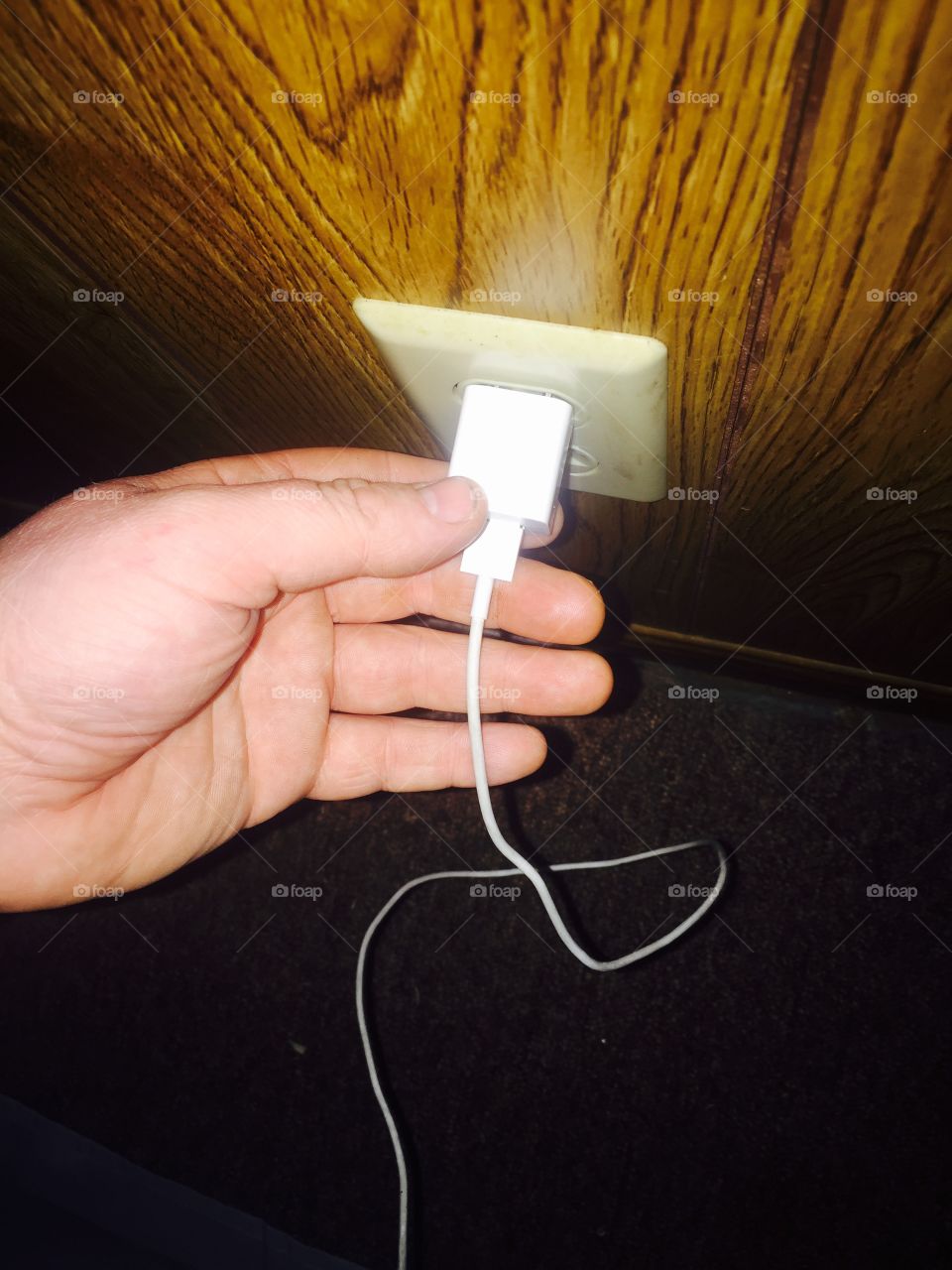 Hand plugging in USB charger for apple iphone