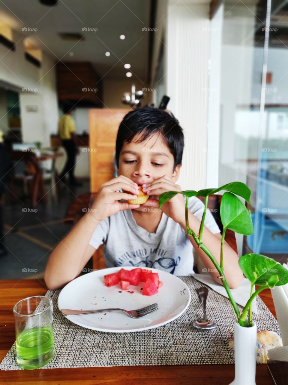small boy eating breakfast at a hotel or resort restaurant in the morning