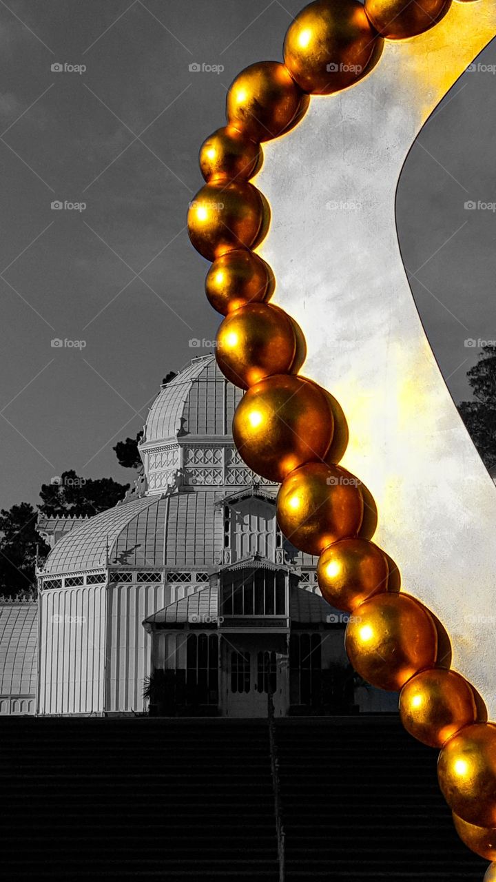 Black and white image of the Conservatory of Flowers in Golden Gate Park in San Francisco California as seen through the Golden sculpture in the gardens 
