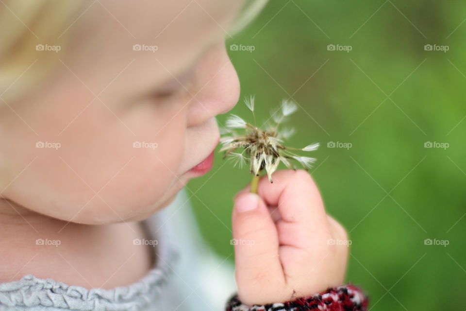 Kind and flower.Ребенок держит в руке одуванчик.