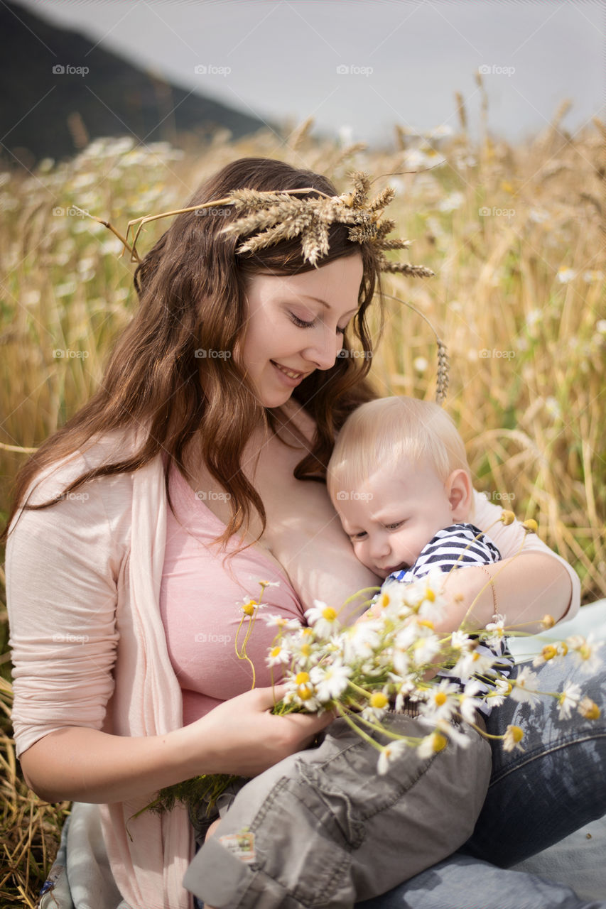 Close-up of mother holding her baby in field