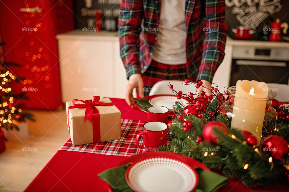 man sets a beautiful decorated winter table for a festive dinner.  Merry Christmas and Happy New Year.