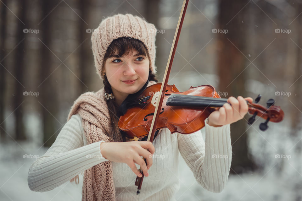 Teenage girl portrait with violin in winter park