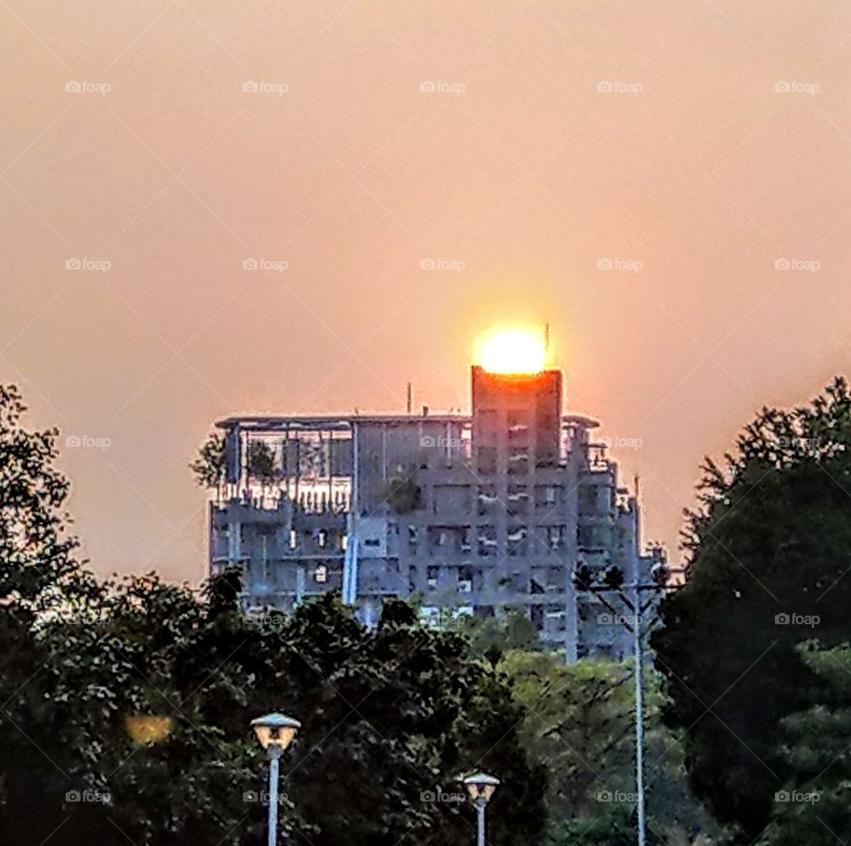 sunrises, sunsets and the moon: capturing sunset like a scoop of icecream on the specil building in urban area.