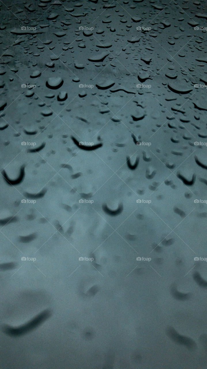 Rain droplets on the car windshield from inside