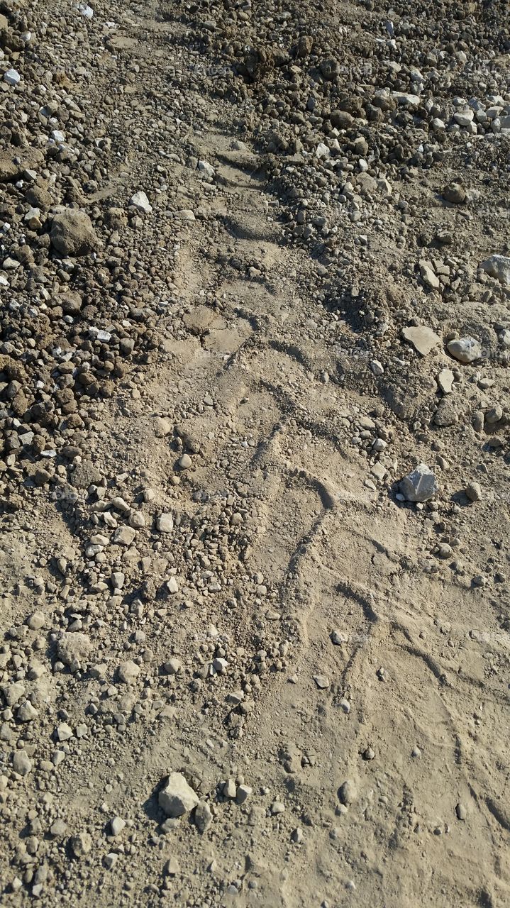 large tire tracks on rocky soil