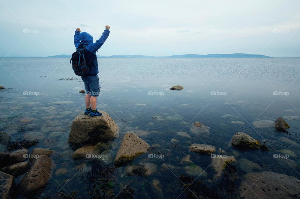 Man on the rock in Atlantic ocean at Barna, Galway, Ireland