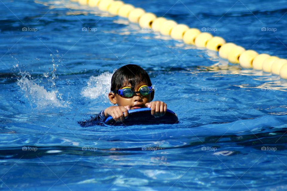 young kid swimming in a swimming pool