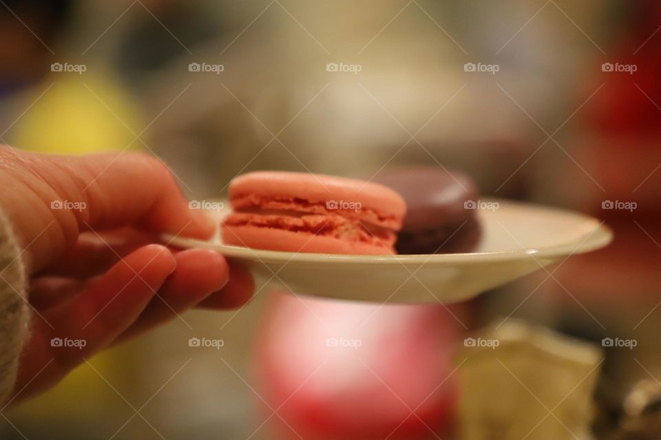 hand holding plate with macarons 