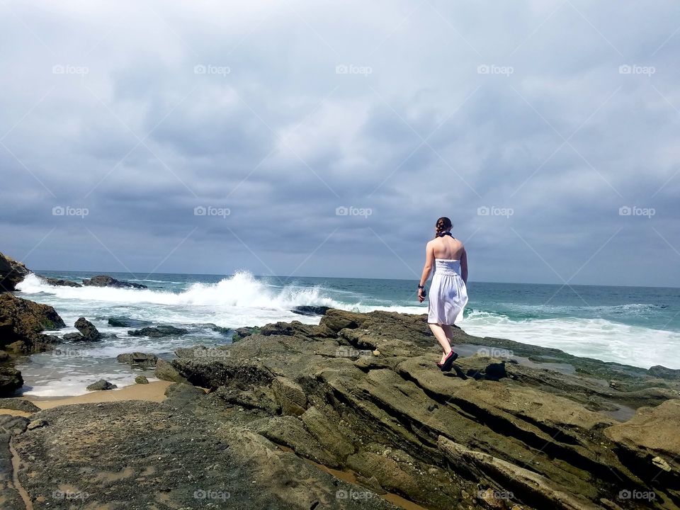 girl walking towards waves