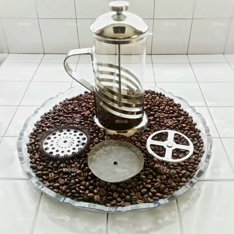 Deconstructed French Press Sitting On Coffee Beans on Kitchen Counter