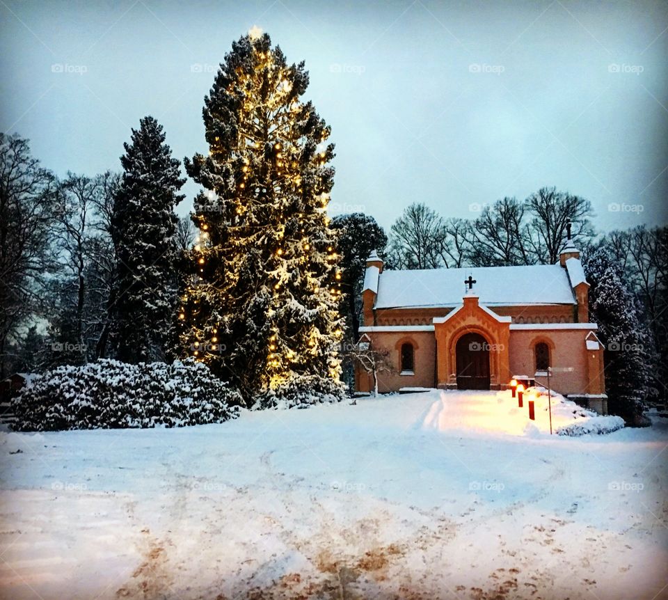 Church and Christmas tree in the snow in Finland 